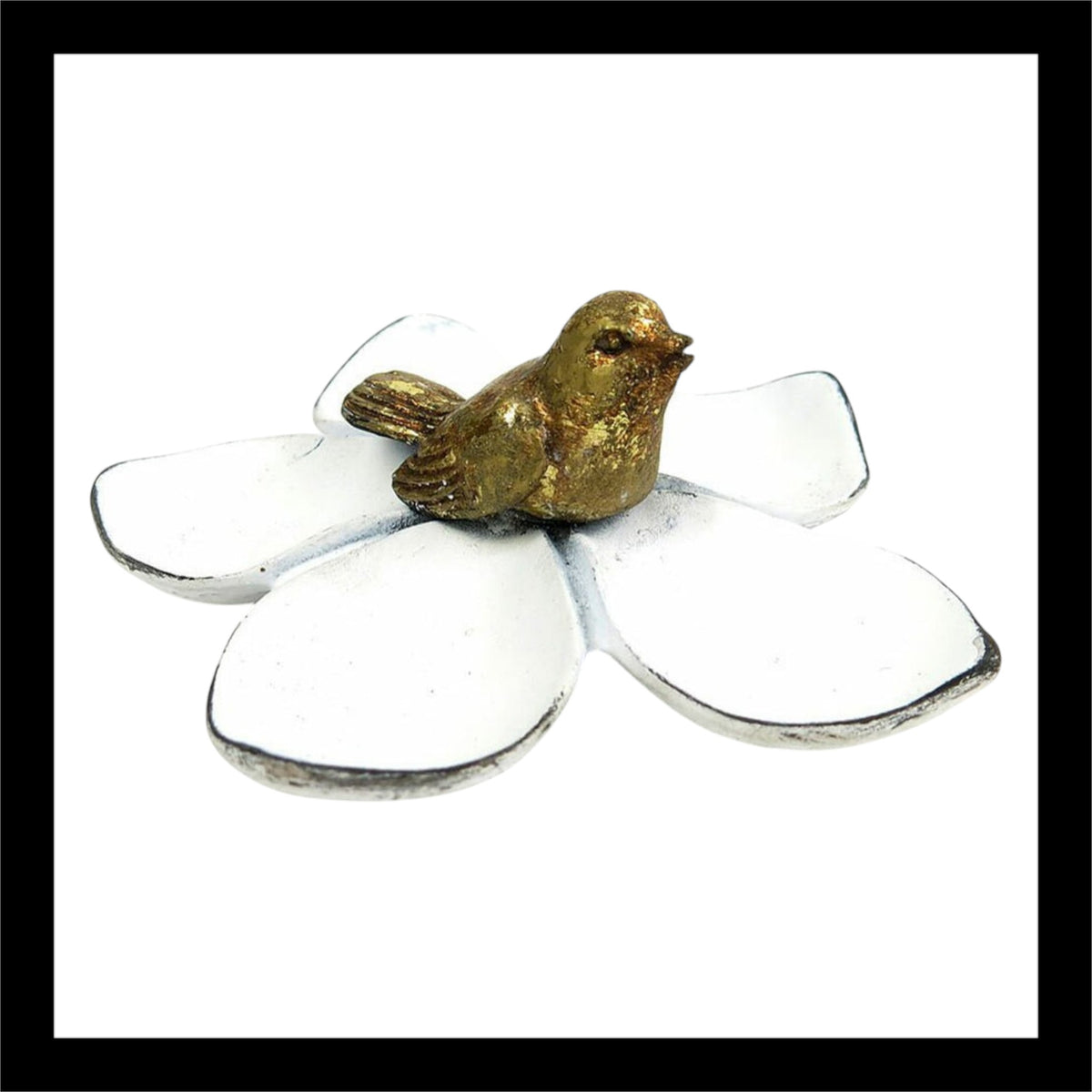 A charming white flower-shaped jewelry tray featuring a delicate gold bird figurine perched at the center. This vintage-inspired tray measures 4.25 inches by 4.25 inches by 1.75 inches, making it a perfect accent piece for holding rings, earrings, or small trinkets. Ideal for vanity or bedside décor.