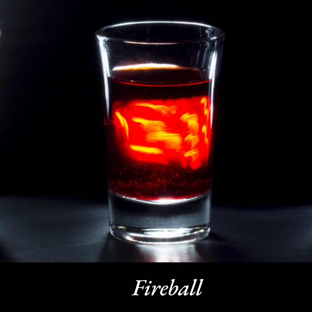 A shot glass filled with orange glowing fireball whiskey. 