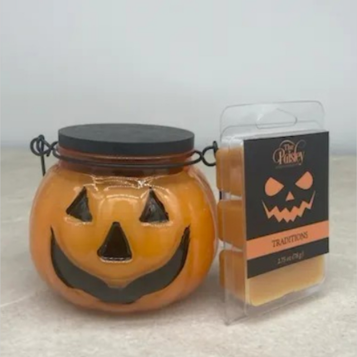 Traditions fall scented candle in orange jack-o'-lantern jar with matching wax melt