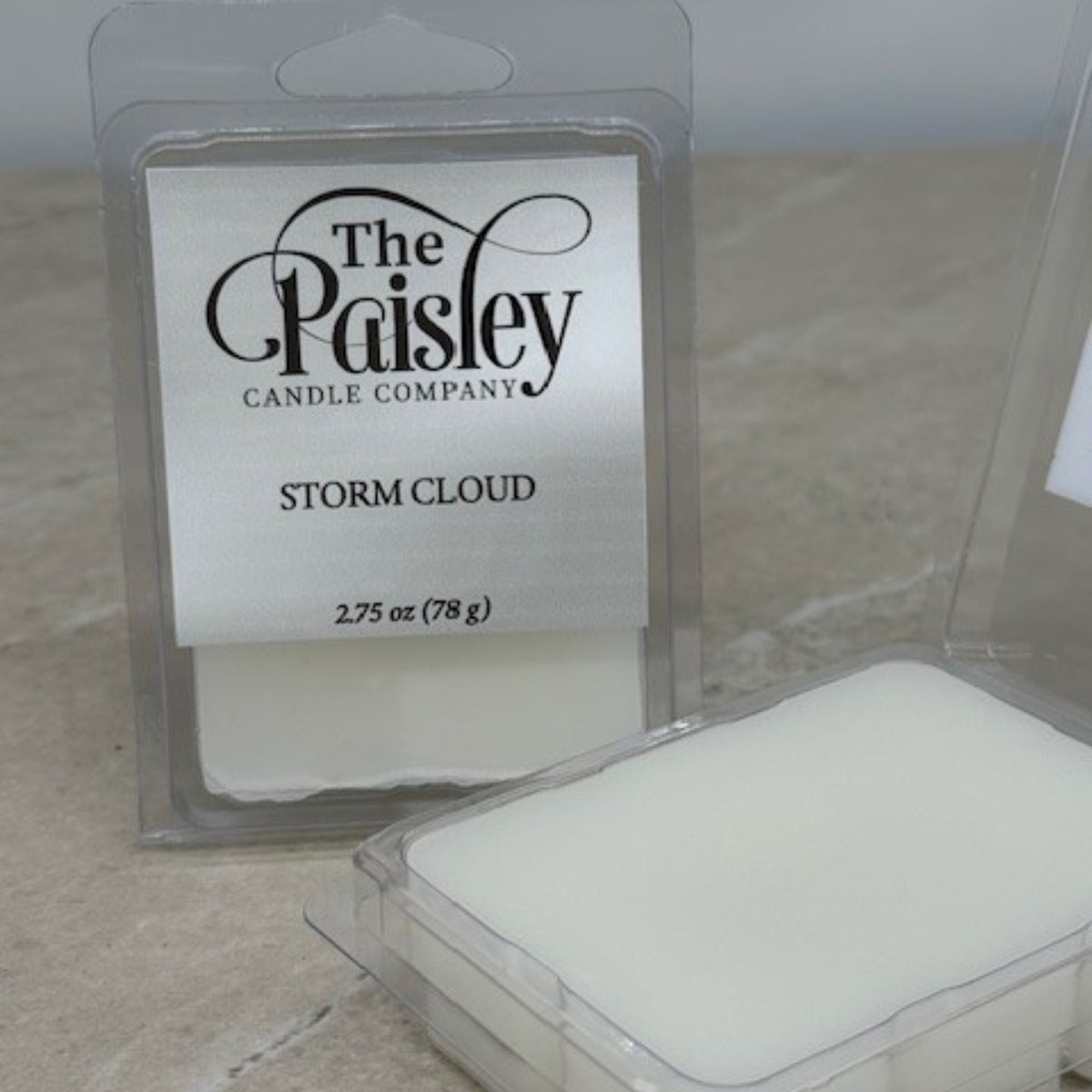 Storm Cloud wax melt by Paisley Candle Company shown in open clamshell packaging on neutral background